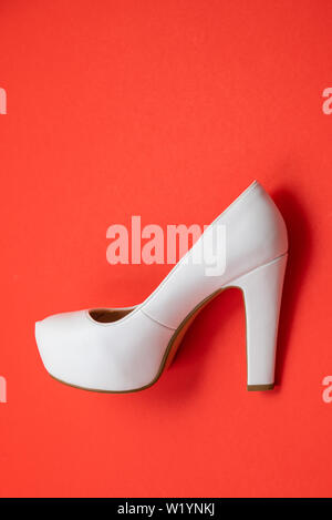 White high heeled shoes on red background - top view concept - blank empty room space for text or copy. Suitable for holidays like Valentine's or Chri Stock Photo