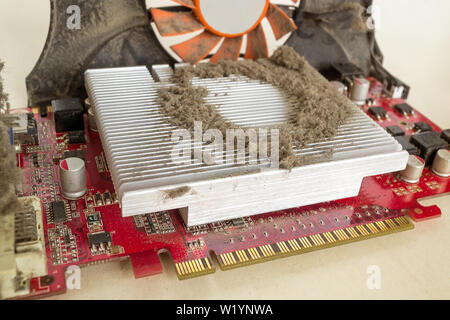 Dusty external graphics card out of a personal computer case for cleaning. A lot of dust on the cooling radiator of the video card processor, dirty pc Stock Photo