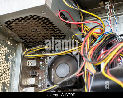 Power supply and wires inside of the personal computer case are covered with dust. A lot of dust under the cooler on the processor radiator. Time to c Stock Photo