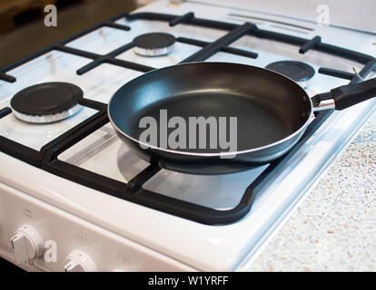 Empty frying pan on a gas stove burner Stock Photo