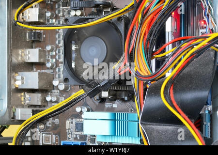 Mainboard and cables inside of the personal computer case are covered with dust. A lot of dust under the cooler on the processor radiator. Time to cle Stock Photo