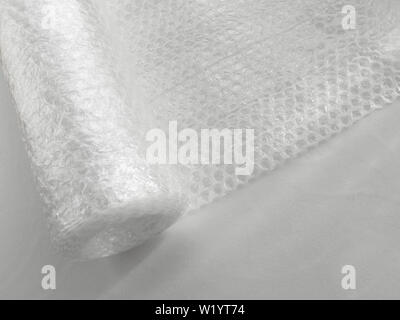 White transparent bubble wrap roll for packaging fragile items on a white background, view from above. Stock Photo