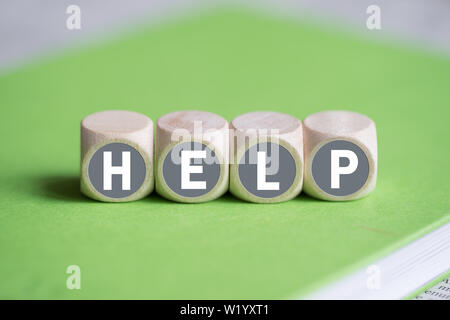 dice on a notebook forming the word HELP Stock Photo