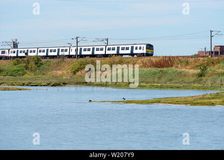 British Rail Class 321 alternating current (AC) electric multiple unit EMU train on the east coast line of Greater Anglia railway near Manningtree Stock Photo