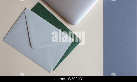 Colorful envelopes, laptop and cardboards on table. Mockup. Office concept. Stock Photo