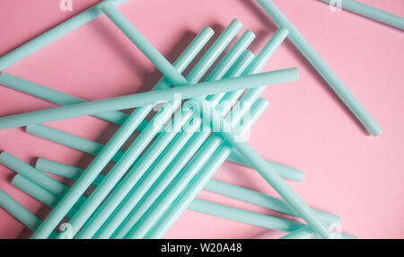 Mint green plastic straws on soft pink background. Set for party. Stock Photo
