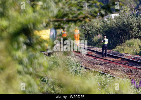 Margam, Wales, UK. 3rd July, 2019. Police by the stranded train on the tracks near Margam in south Wales, UK. Wednesday 03 July 2019 Re: Two rail workers have died after being hit by a passenger train between Port Talbot Parkway and Bridgend stations in south Wales, UK. The pair were struck near Margam by the Swansea to London Paddington train at about 10am. They were pronounced dead at the scene and a third person was treated for shock, but was not injured. Credit: ATHENA PICTURE AGENCY LTD/Alamy Live News Stock Photo