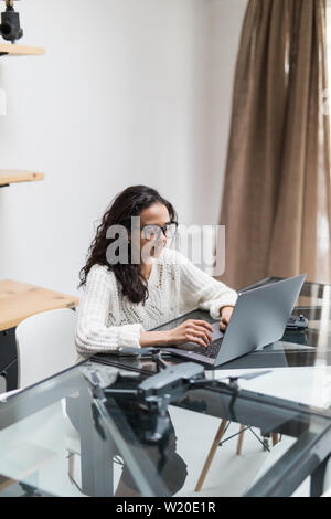 Young woman using laptop in home office Stock Photo