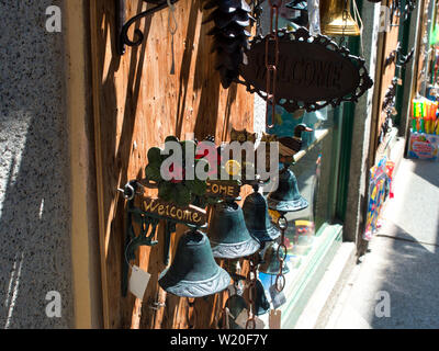 Welcome bells as souvenirs on display by a village store in Orta San Giulio Italy on a summer morning Stock Photo