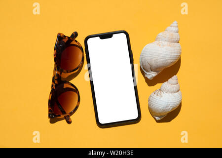Smartphone with sunglasses and shells. Summer holiday concept Stock Photo