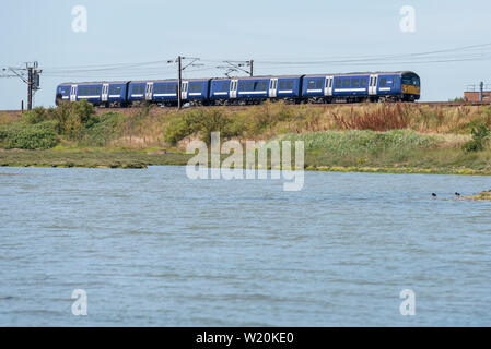 Greater Anglia Abellio British Rail Class 360 Desiro train on the east coast line of Greater Anglia railway near Manningtree, Essex. River Stour Stock Photo