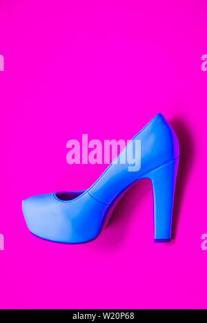 Blue high heeled shoes on pink purple background - top view concept - blank empty room space for text or copy. Classic dress up fashion. Profile of he Stock Photo