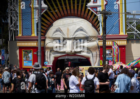 People on closed off streets outside the iconic Luna Park face, entrance into the fun park during the St Kilda Festival in Melbourne, Australia. Stock Photo