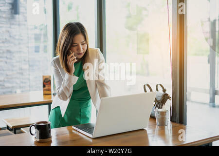 business woman working with use computer and smartphone in coffee shop. business relaxing and break time. freelance working and freedom work. business Stock Photo