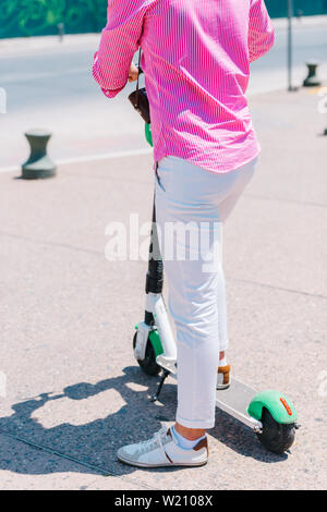 Close up view of legs of man on electric scooter outdoor Stock Photo