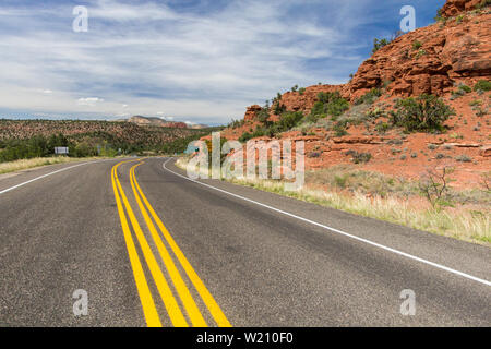 Double Yellow Line On Mountain Road. Double yellow no passing line on a winding mountain road through the red rocks and in Sedona Arizona. Stock Photo