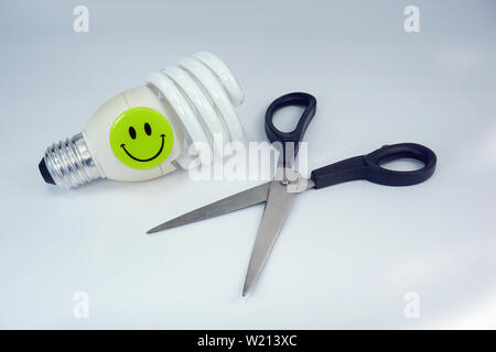 Save Money Cut Cost wallet scissors energy saving bulb electricity smiley happy on white background Stock Photo