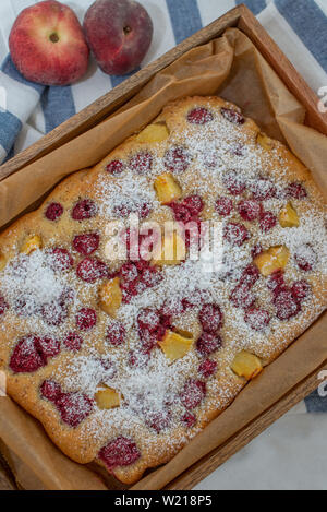 Home made almond cake with peach and raspberries Stock Photo