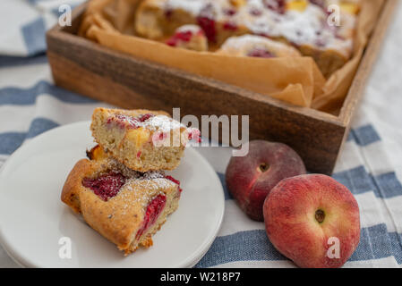 Home made almond cake with peach and raspberries Stock Photo