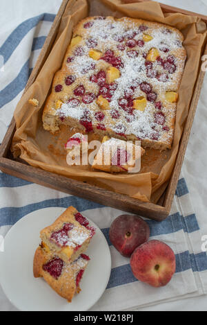 Home made almond cake with peach and raspberries Stock Photo