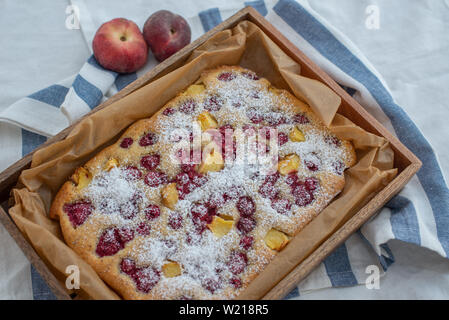 Home made almond cake with peach and raspberries Stock Photo