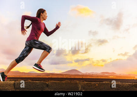Athlete trail running silhouette of a woman runner at sunset sunrise. Cardio fitness training of marathon race sportswoman. Active healthy lifestyle in summer nature outdoors. Stock Photo