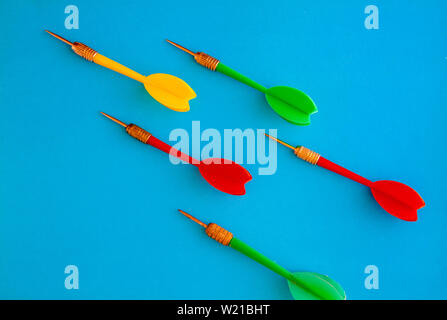 Multicolored red yellow green darts arrows on yellow violet blue background. Flat lay. View from above. Copy space. The concept of hitting the target, Stock Photo