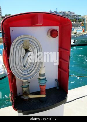 Fire hose reel at a marina. Stock Photo