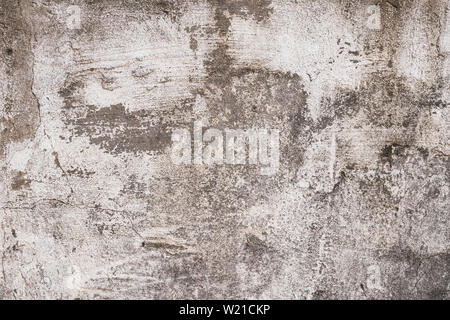 Gray and brown shabby concrete wall with flaky plaster. Torn rough old cement wall texture, background. Vintage, natural cracked distressed background Stock Photo