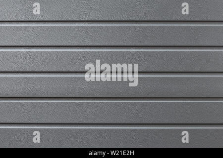 Metal reflective gray grooved surface. Grey metalline background, texture. Metallic gate in the line close-up. Abstract ribbed textural iron wall patt Stock Photo