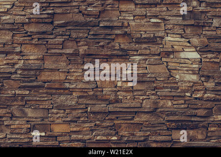 Textured surface of a brown dirty stone wall. Old red brick wall background. Concrete bricks wall pattern. Grunge granite texture. Mineral grungy back Stock Photo