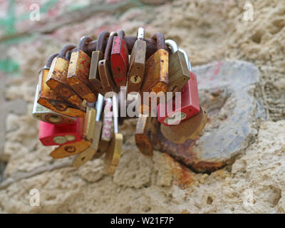 several pad locks arranged in a circle on a stone wall Stock Photo