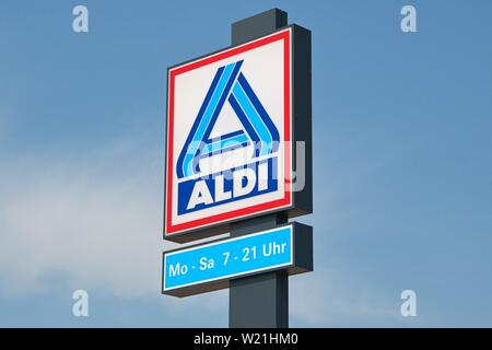 Aldi supermarket sign with opening hours, Abergavenny, Wales, UK Stock