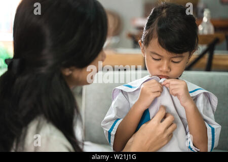 kindergarten student wearing school uniform helped by her mom in the morning. back to school preparation Stock Photo