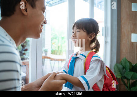 kindergarten student wearing school uniform helped by her father in the morning. back to school preparation Stock Photo