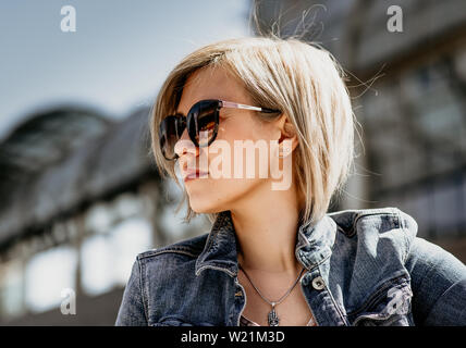 Portrait of a beautiful blonde in sunglasses. Close-up, side view. Stock Photo