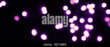 Purple bokeh lights scattered on black. Holiday concept. Stock Photo