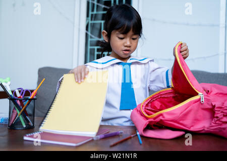 independent young kindergarten student preparing her own stuff before going to school in the morning Stock Photo