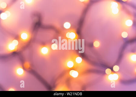 Christmas or party concept. Golden bokeh lights on blurred pink background. Stock Photo