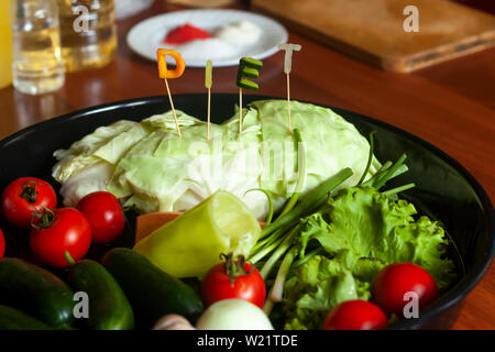 Diet word made cut from vegetables and dish of fresh vegetables. Fresh and healthy food concept. Stock Photo