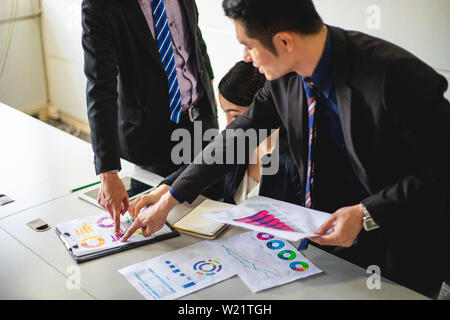 businessmen working and point on graph financial diagram and analysis documents on office table Stock Photo