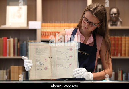 A Sotheby's employee handles the Beatles' first contract with manager Brian Epstein, marking the start of their transformation into world-conquering pop band, photographed before being offered at auction by Sotheby's in London where it is estimated to fetch £200,000 to £300,000. Stock Photo