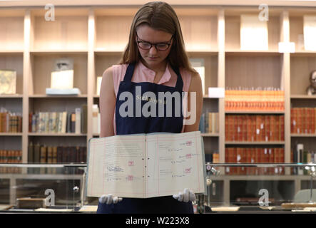 A Sotheby's employee handles the Beatles' first contract with manager Brian Epstein, marking the start of their transformation into world-conquering pop band, photographed before being offered at auction by Sotheby's in London where it is estimated to fetch £200,000 to £300,000. Stock Photo