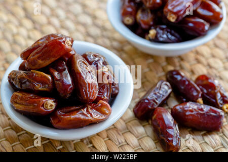 Fresh red dates (hurma) in bowl Stock Photo