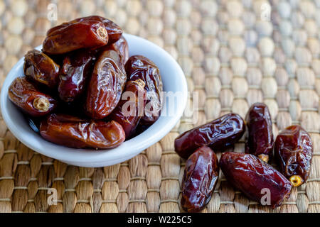 Fresh red dates (hurma) in bowl Stock Photo