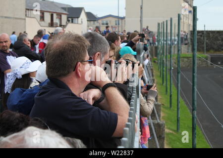 A crowd watching helicopters take off from the tennis courts at Ramore Head at Air Waves 2017 Stock Photo