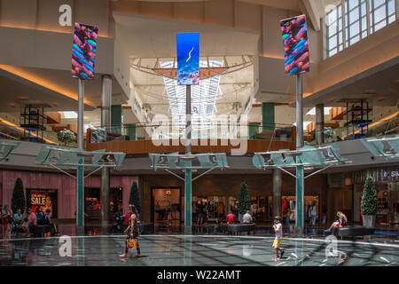 Orlando, Florida. June 6, 2019 .People enjoying their shopping trip in the main hall with top view of screens promoting big brands in The Mall at Mill Stock Photo