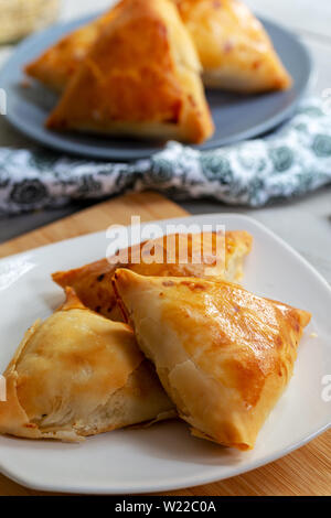 Puff pastry triangles filled minced meat, onion and spices Stock Photo