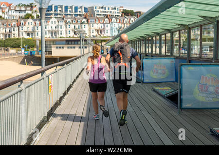 Boscombe, Bournemouth, Dorset, England, UK, 5th July 2019, Weather: Temperatures are on the rise Friday morning making this the warmest day of July so far in what will be a short lived heatwave. Runners on the pier beat the heat. Credit: Paul Biggins/Alamy Live News