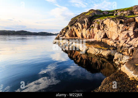 Northern polar summer. Beautiful coastline of Barents sea, rocks reflecting in the calm water surface. Arctic ocean, Kola Peninsula, Russia Stock Photo